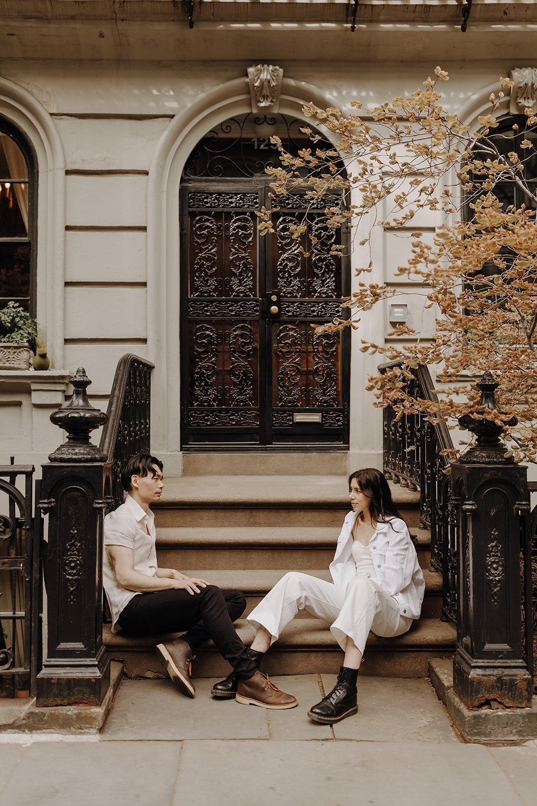 Couple sitting on the stoop during NYC engagement photos in Manhattan