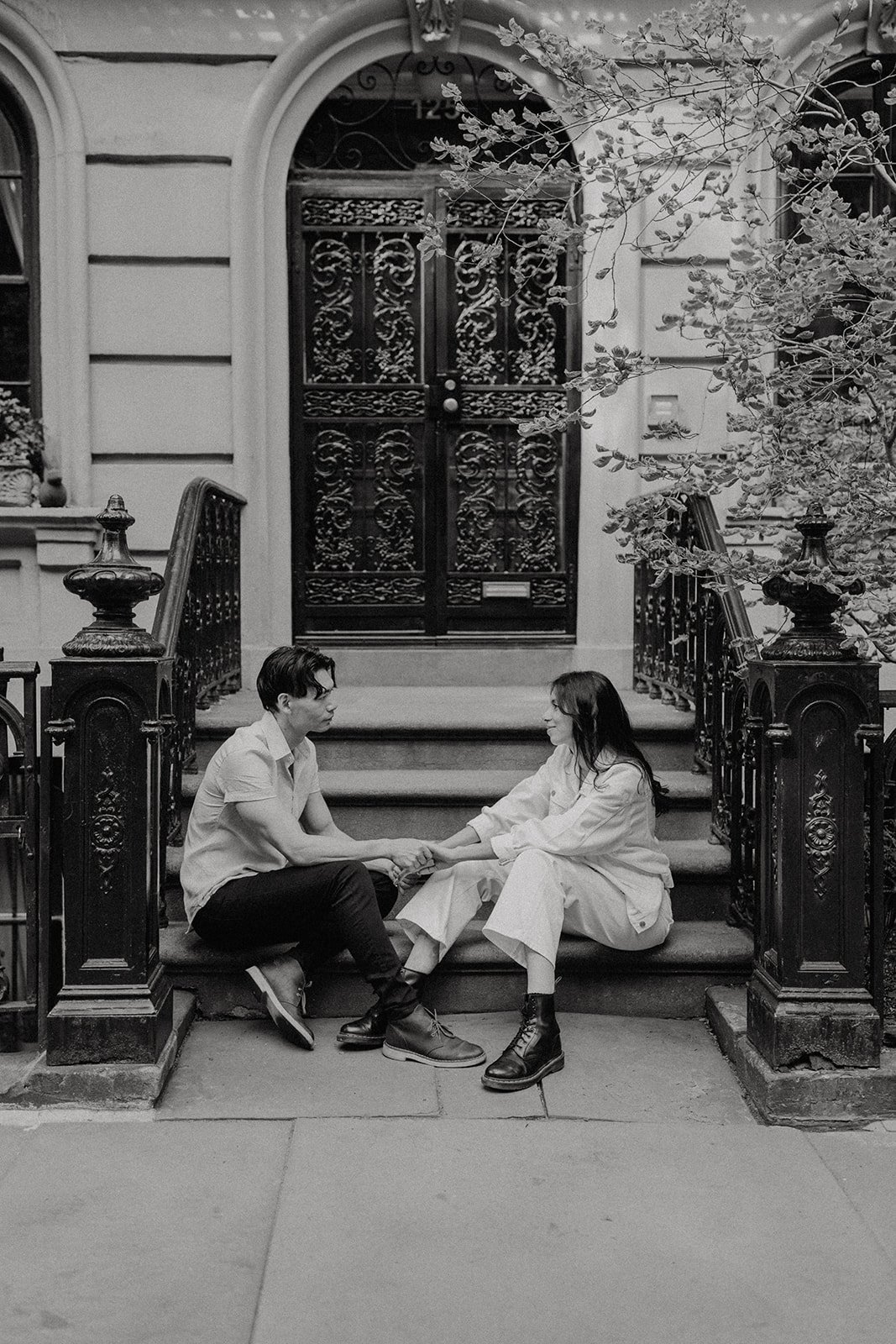 Couple sitting on the stoop during NYC engagement photos in Manhattan