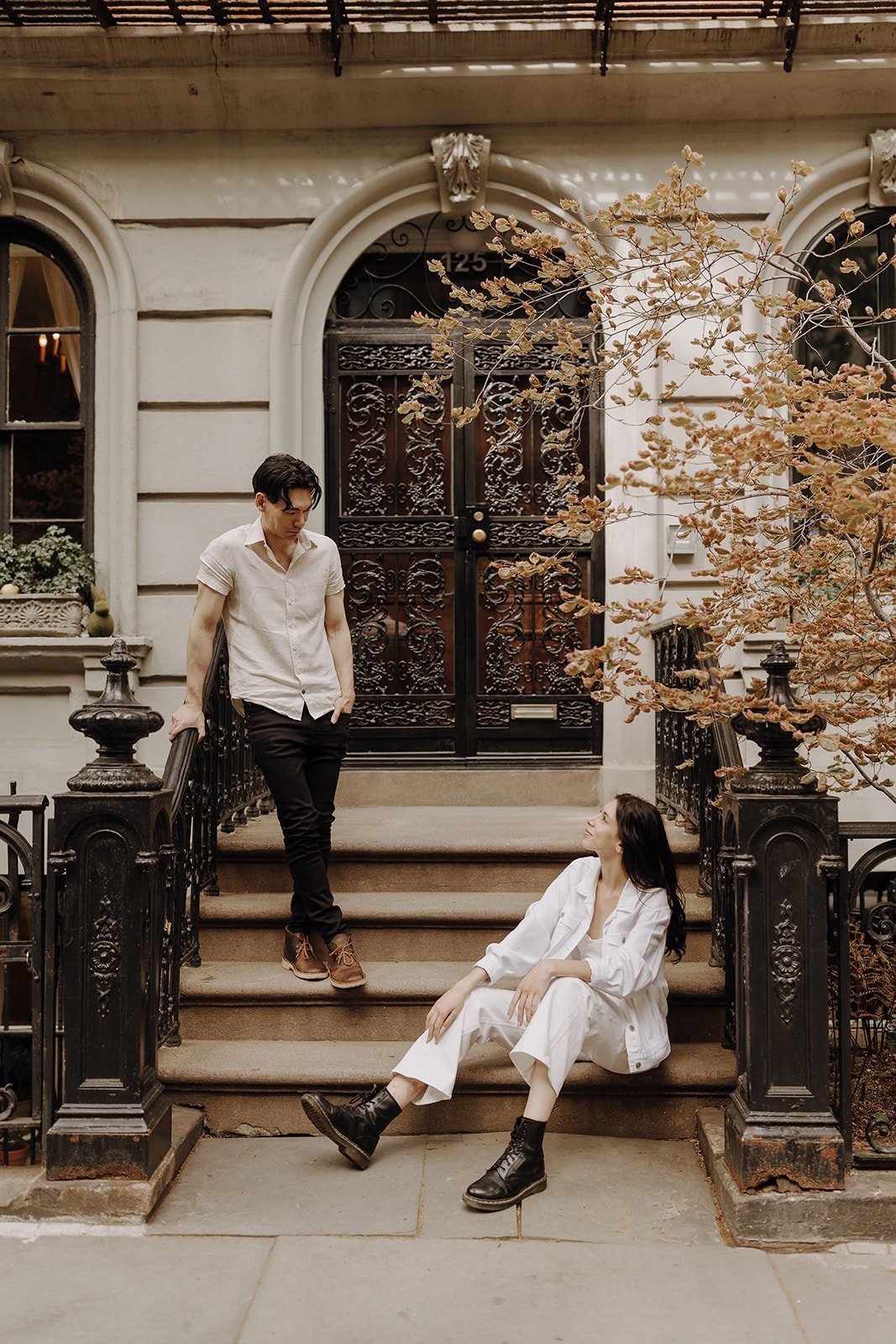 Couple sitting on the stoop during NYC engagement photos in Manhattan