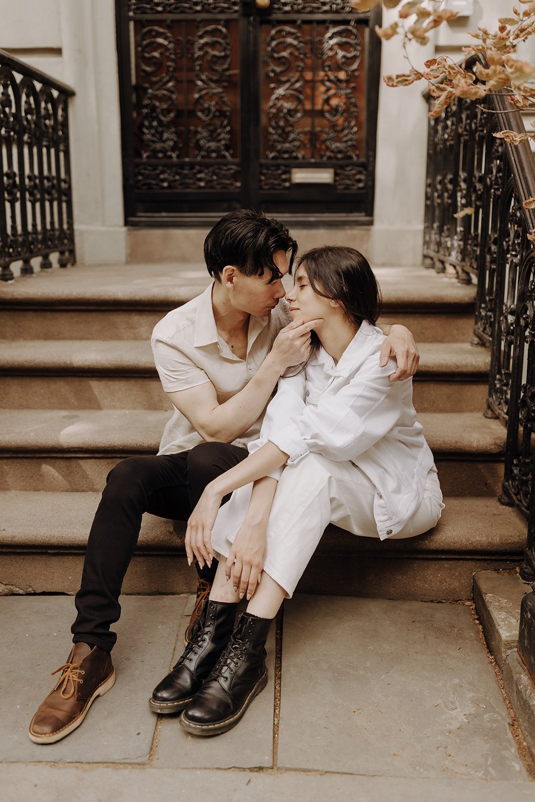 Couple kissing on the stoop during New York City engagement photos