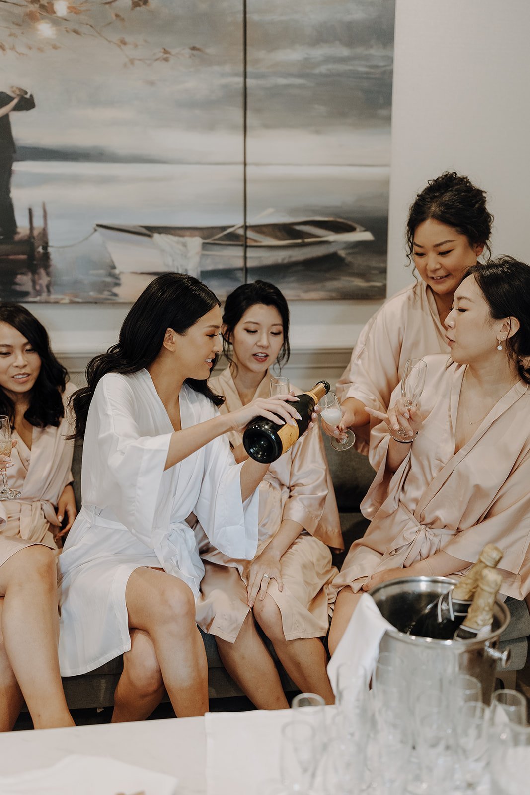 Bride pouring champagne for bridesmaids at NY wedding venue