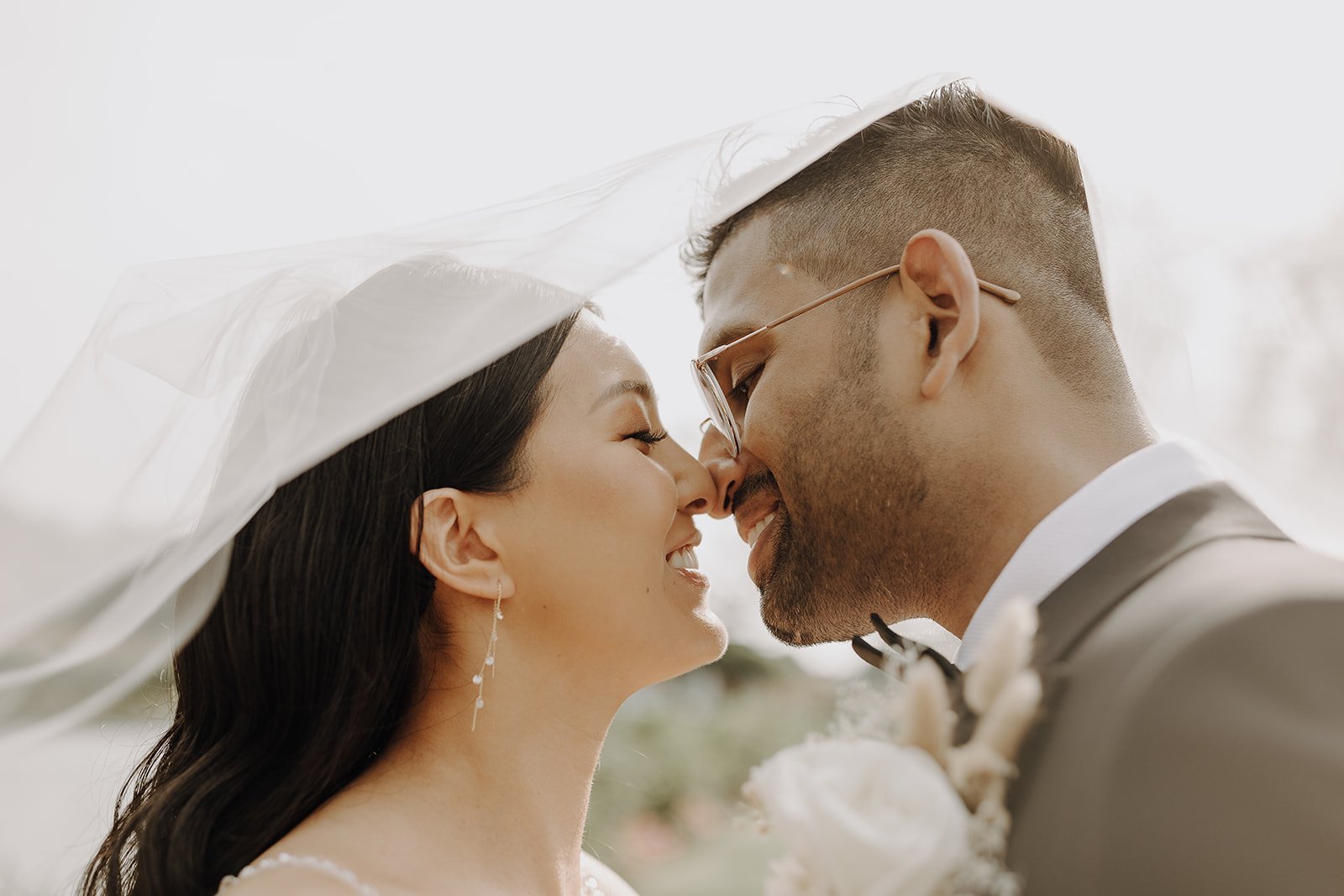 Bride and groom kiss under veil during NYC wedding photos