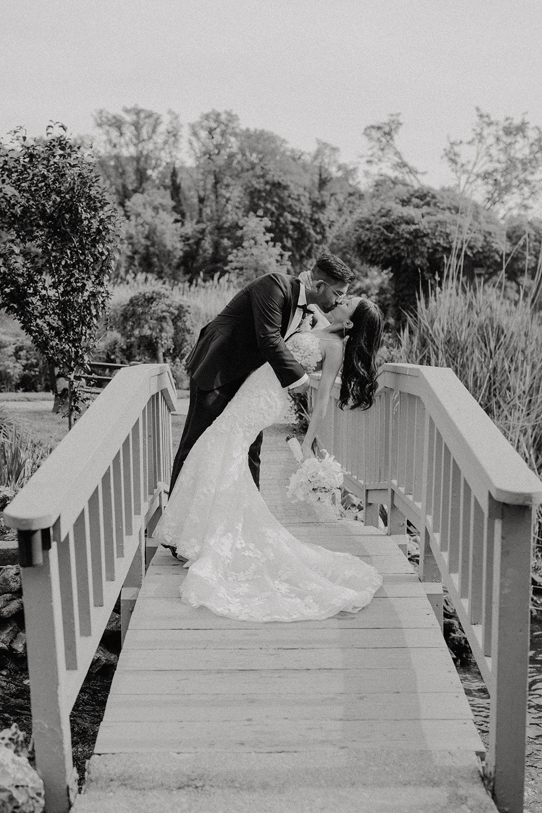 Bride and groom kissing on a bridge during NYC wedding photos