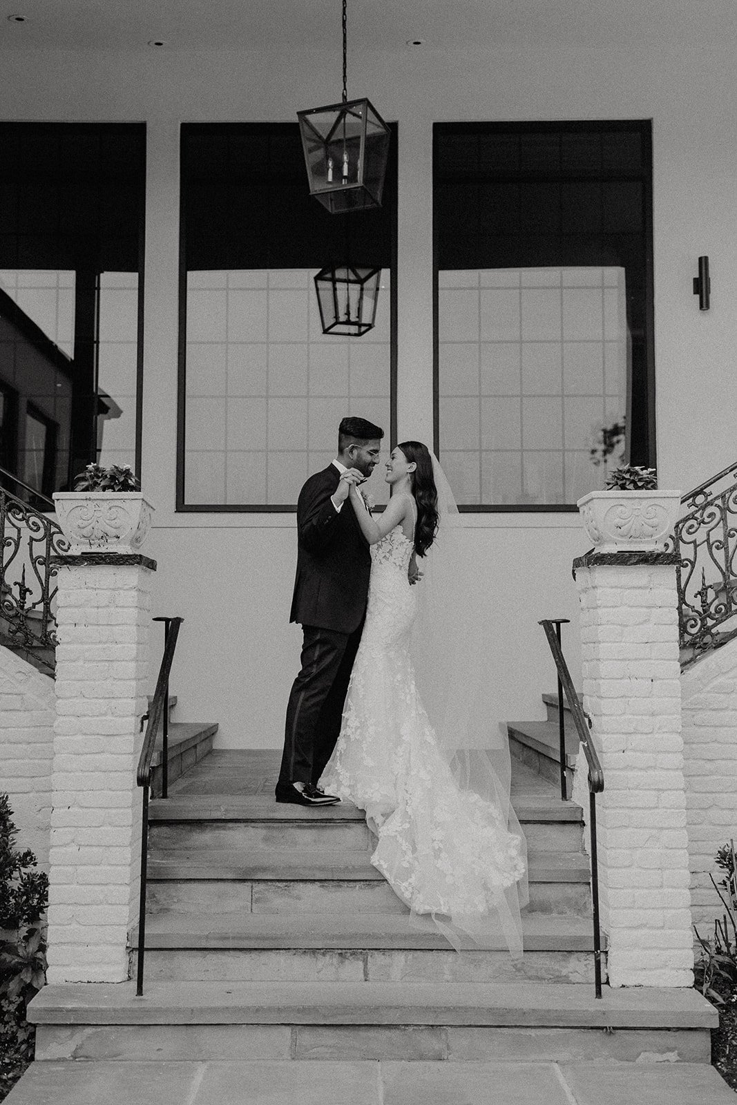 Bride and groom kiss on top of the stairs at NYC luxurious wedding venue