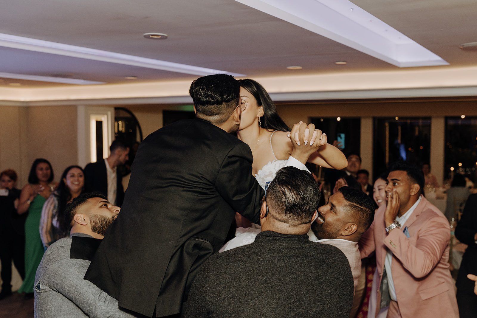 Bride and groom kiss while dancing at city wedding reception in NY