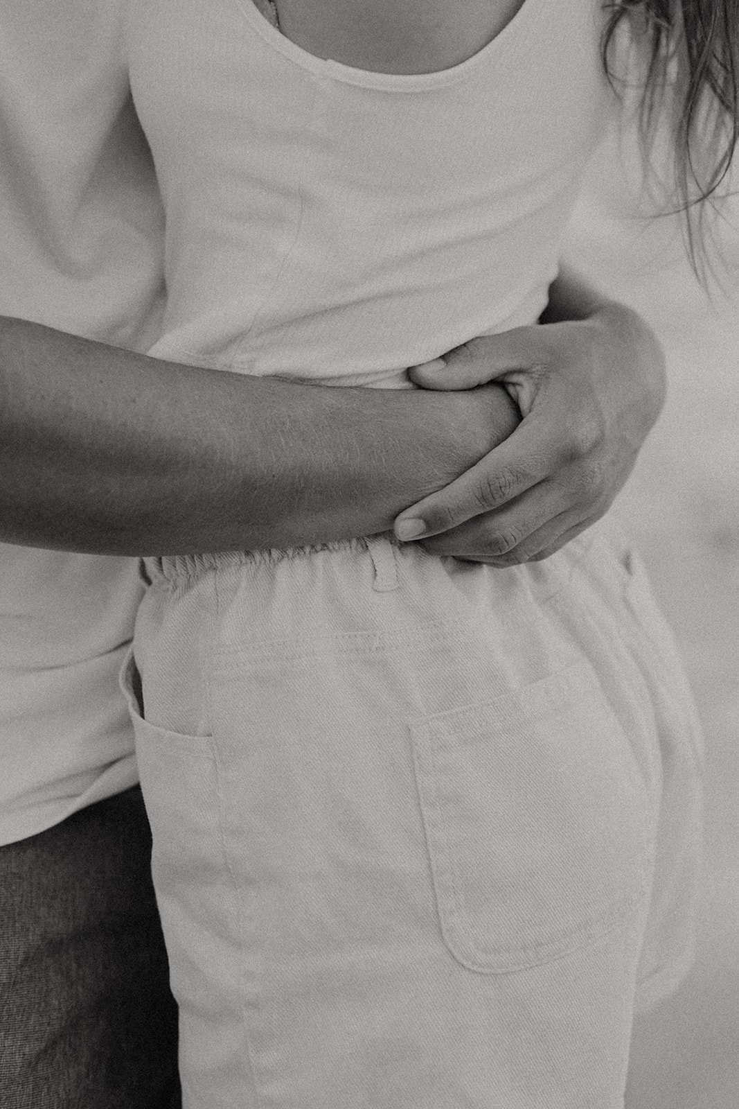 Couple embracing during beach engagement photo session in Kauai