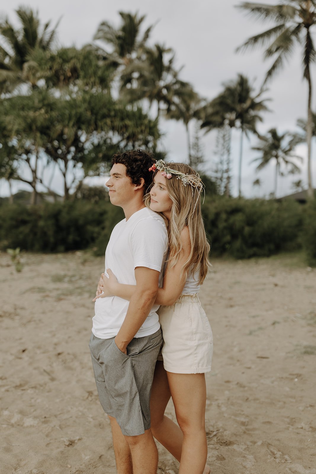 Couple hugging on the beach in Kauai during engagement photo session