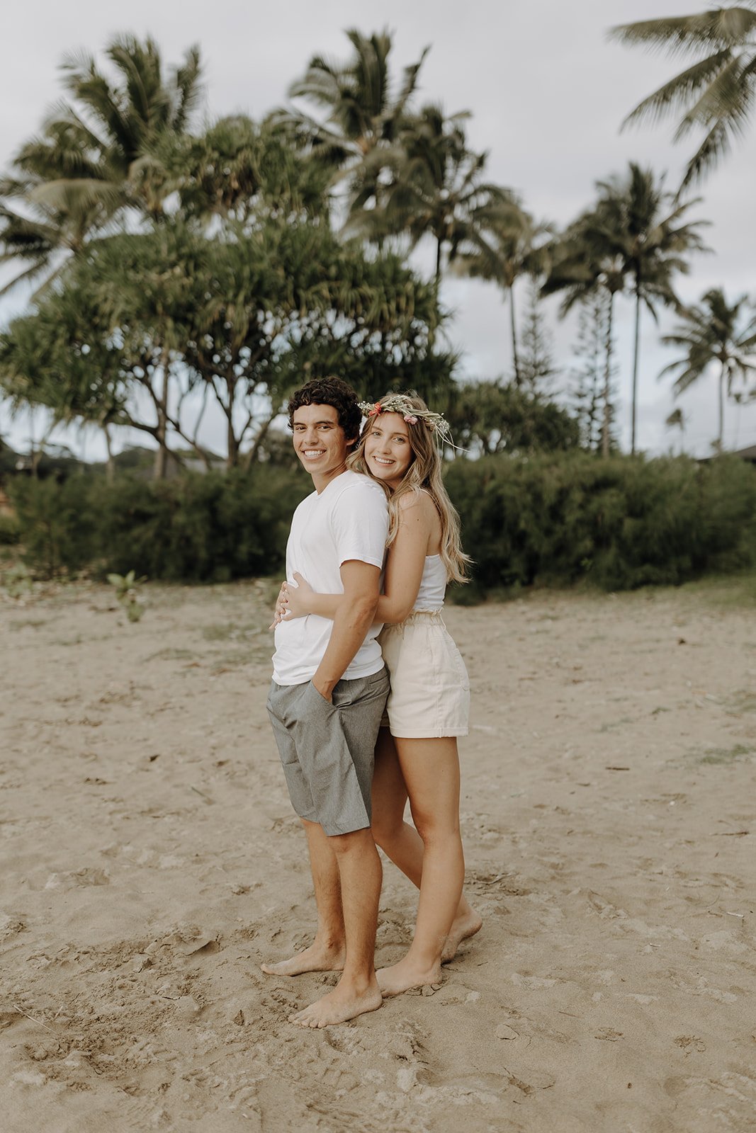 Couple hugging and smiling during engagement photos in Kauai