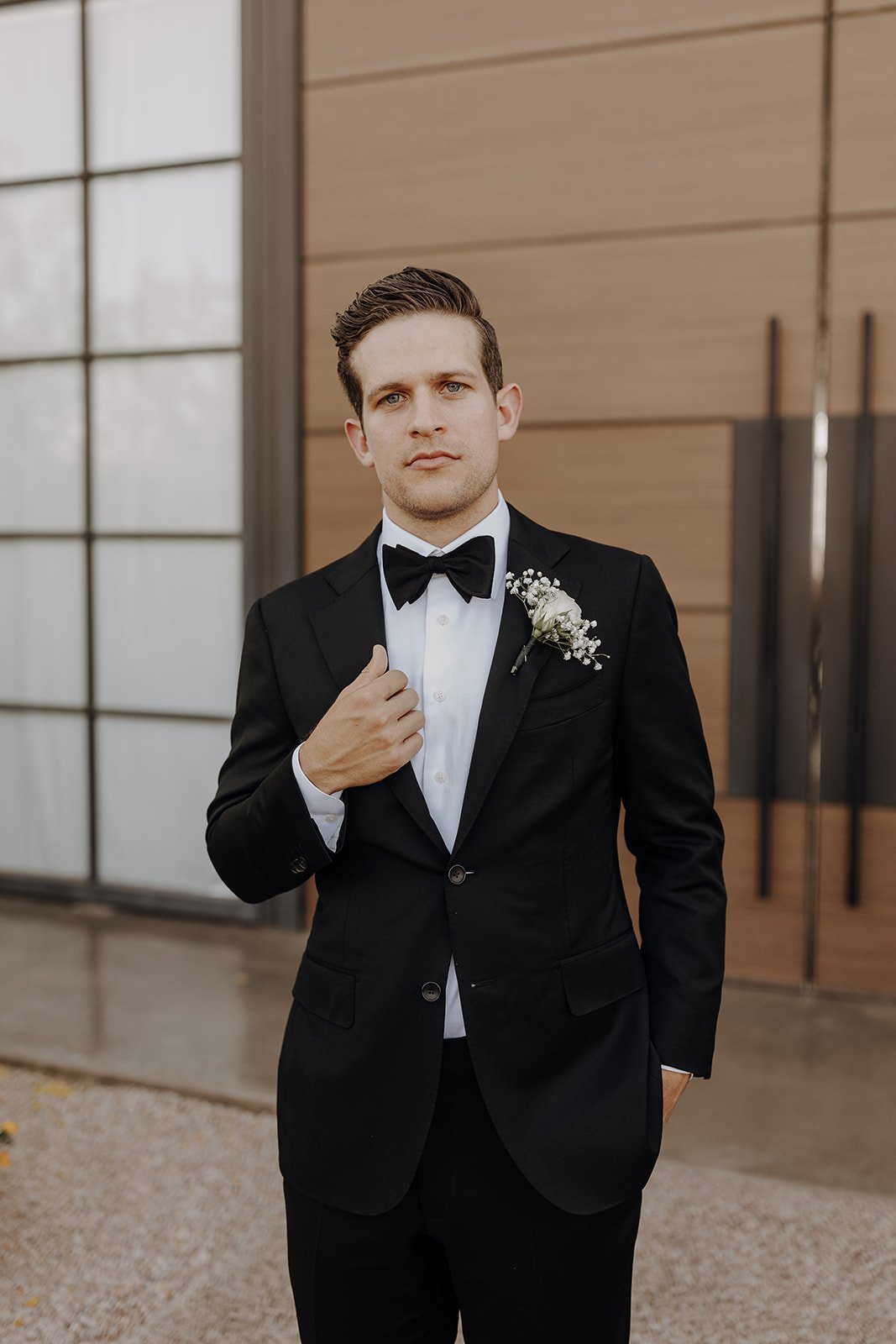 Groom in black suit and white shirt at desert wedding