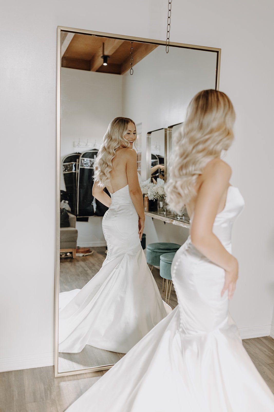 Bride in white dress looking at herself in a mirror at The Paseo desert wedding venue