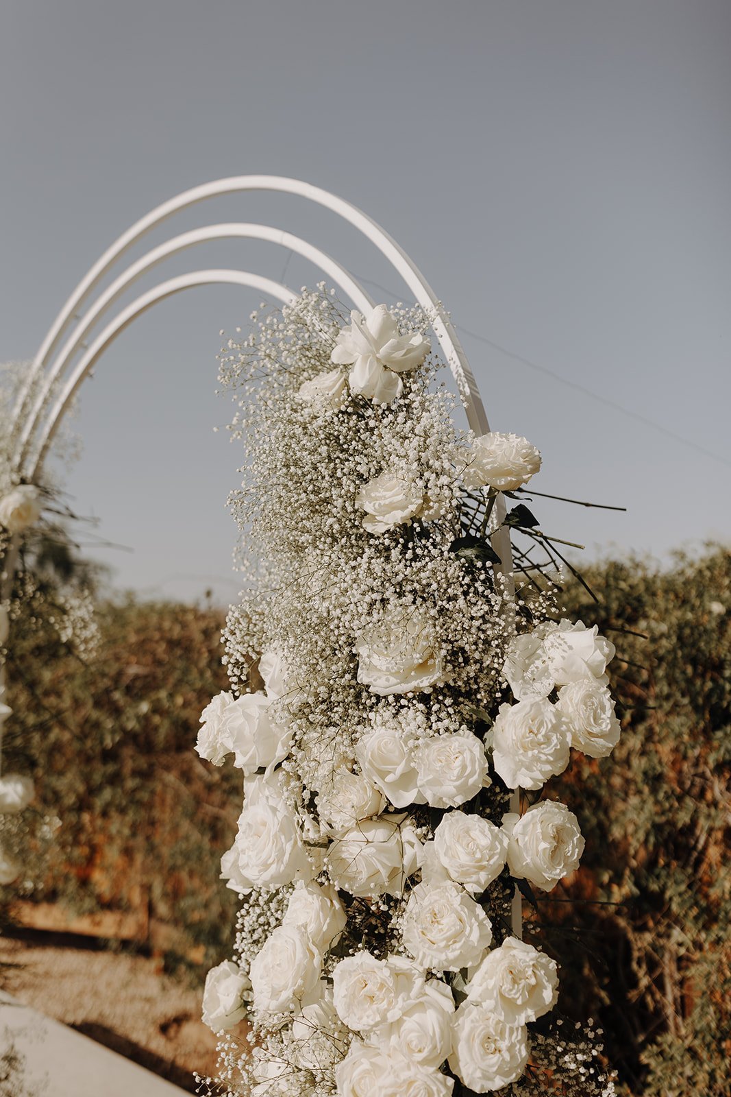 White floral wedding ceremony arch at The Paseo desert wedding venue