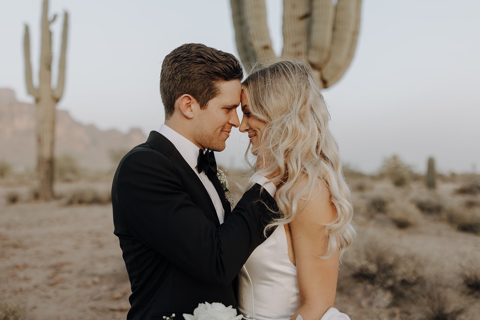 Bride and groom touching foreheads during couple photos in the Arizona desert