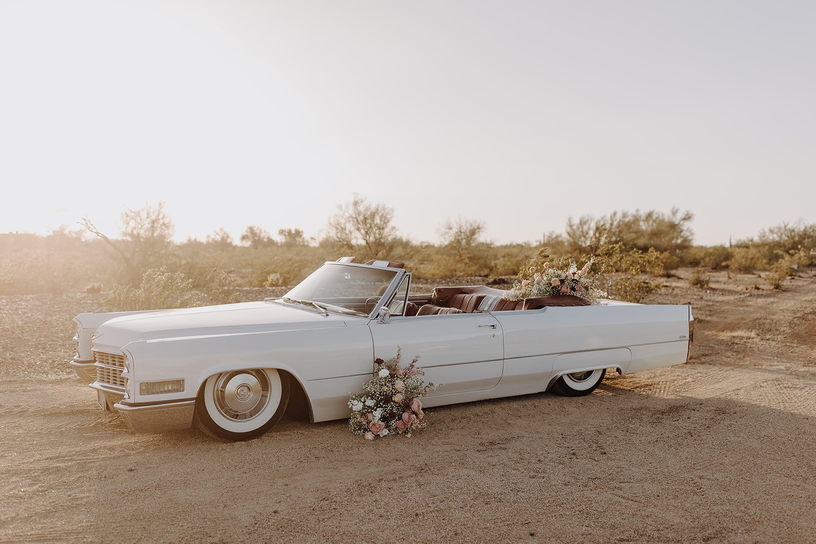 Vintage white convertible getaway car with pink and white flowers