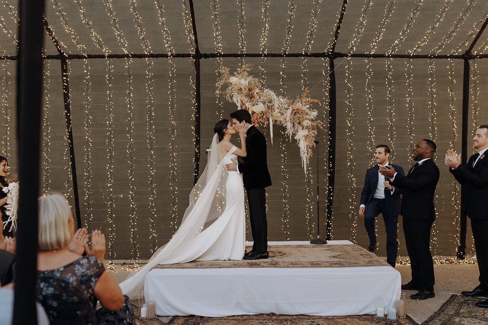 Bride and groom kiss at the altar during Persian wedding