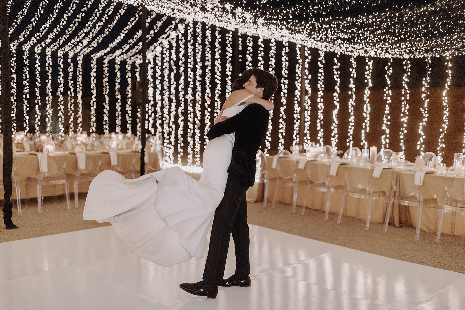 Bride and groom dancing on the dance floor under twinkle lights
