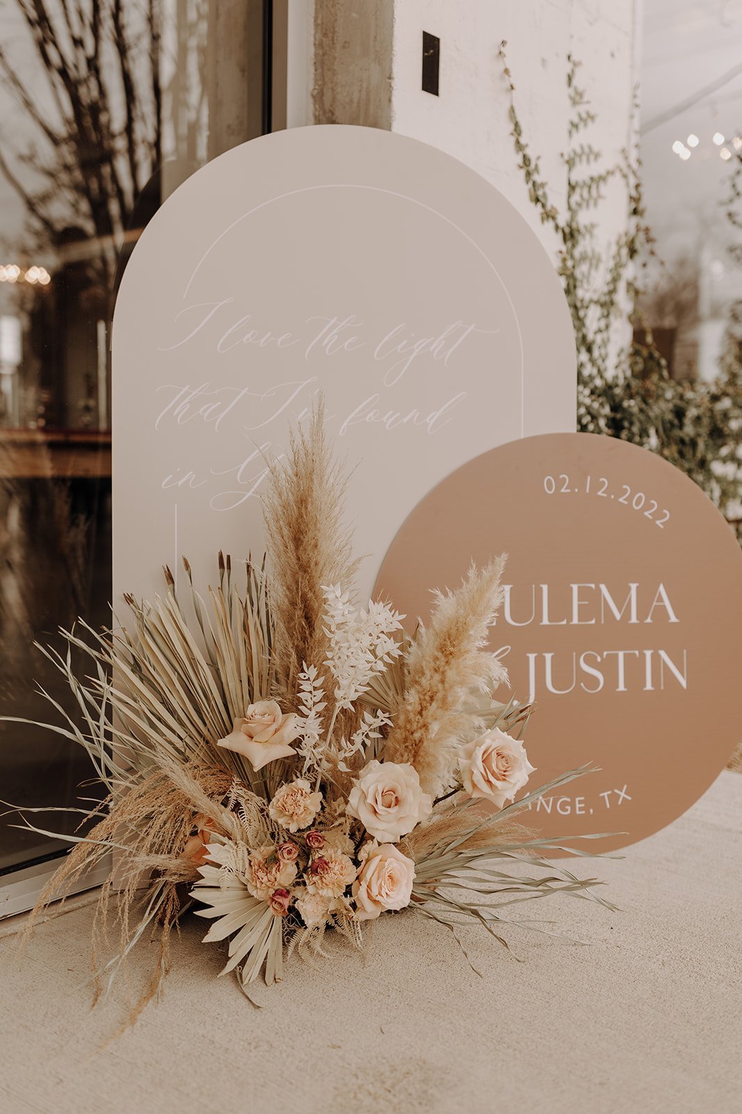Neutral colored wedding reception sign and floral bouquet