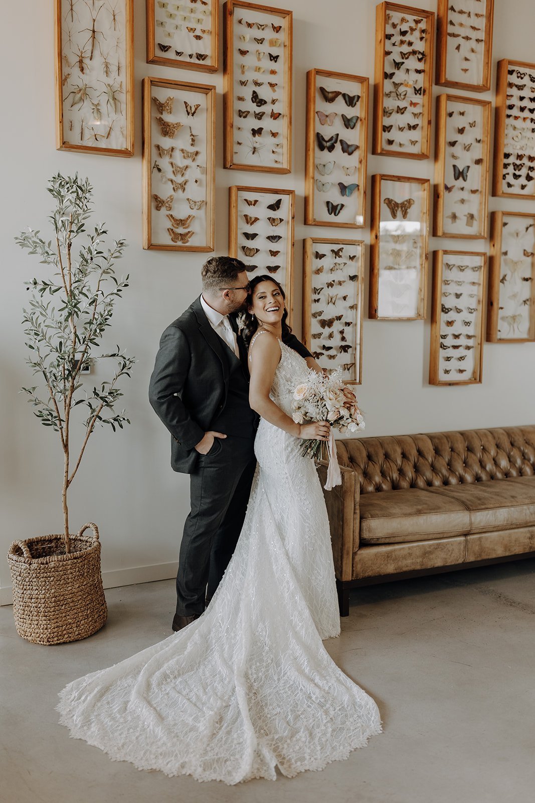 Bride and groom portraits in front of framed butterfly photo wall at the Ice Plant Bldg wedding venue in Austin