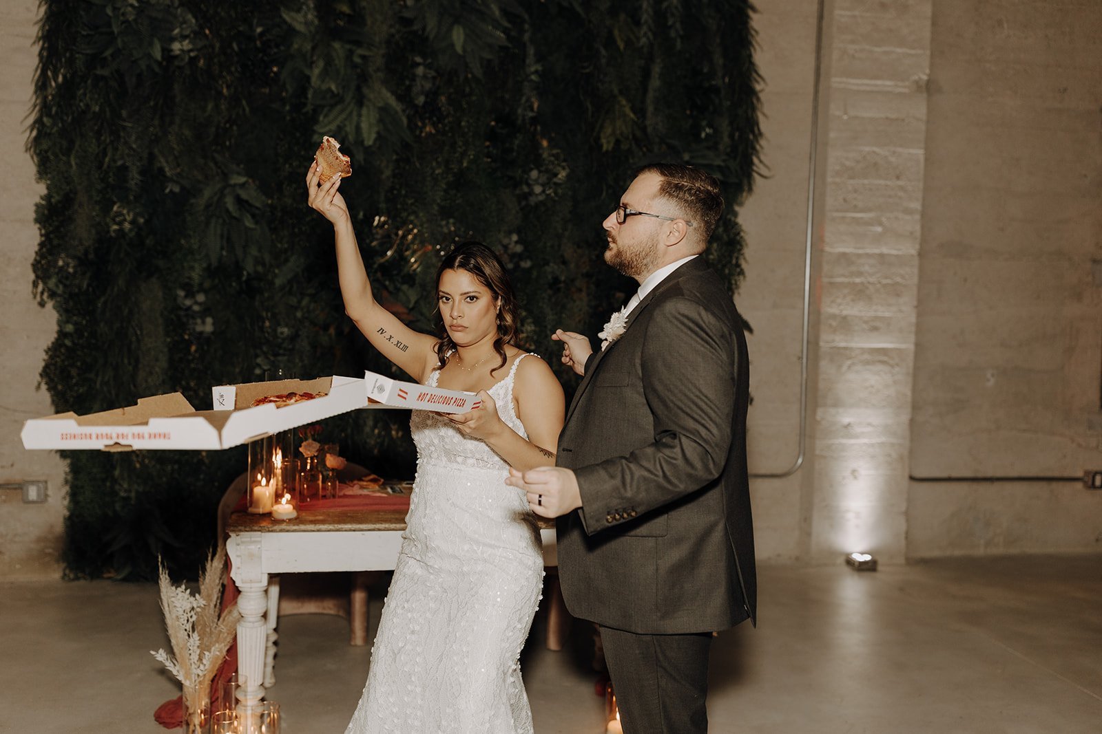 Bride and groom celebrate while holding pizza box at Austin, Texas wedding reception