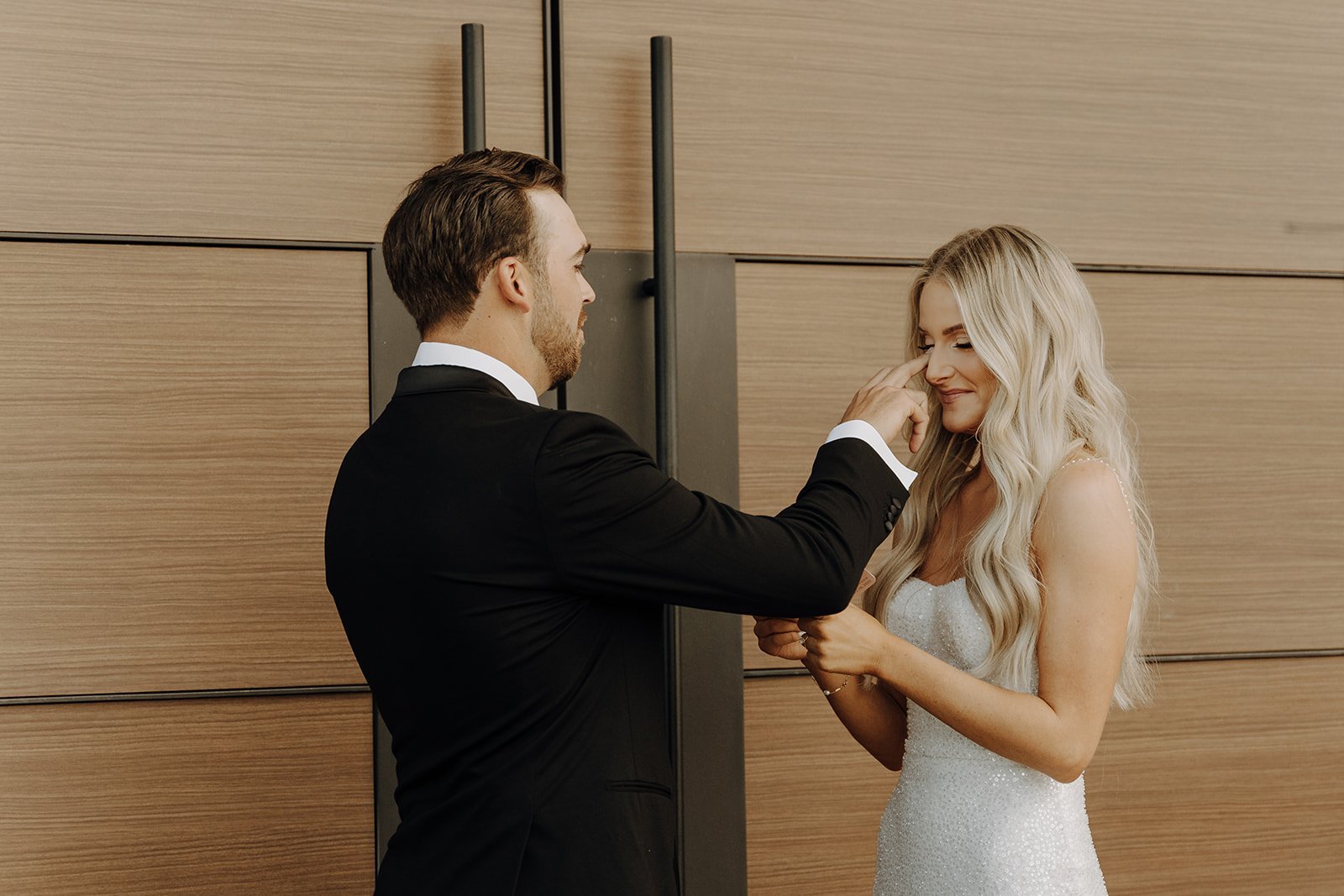 Groom wipes a tear from brides eyes while exchanging vows