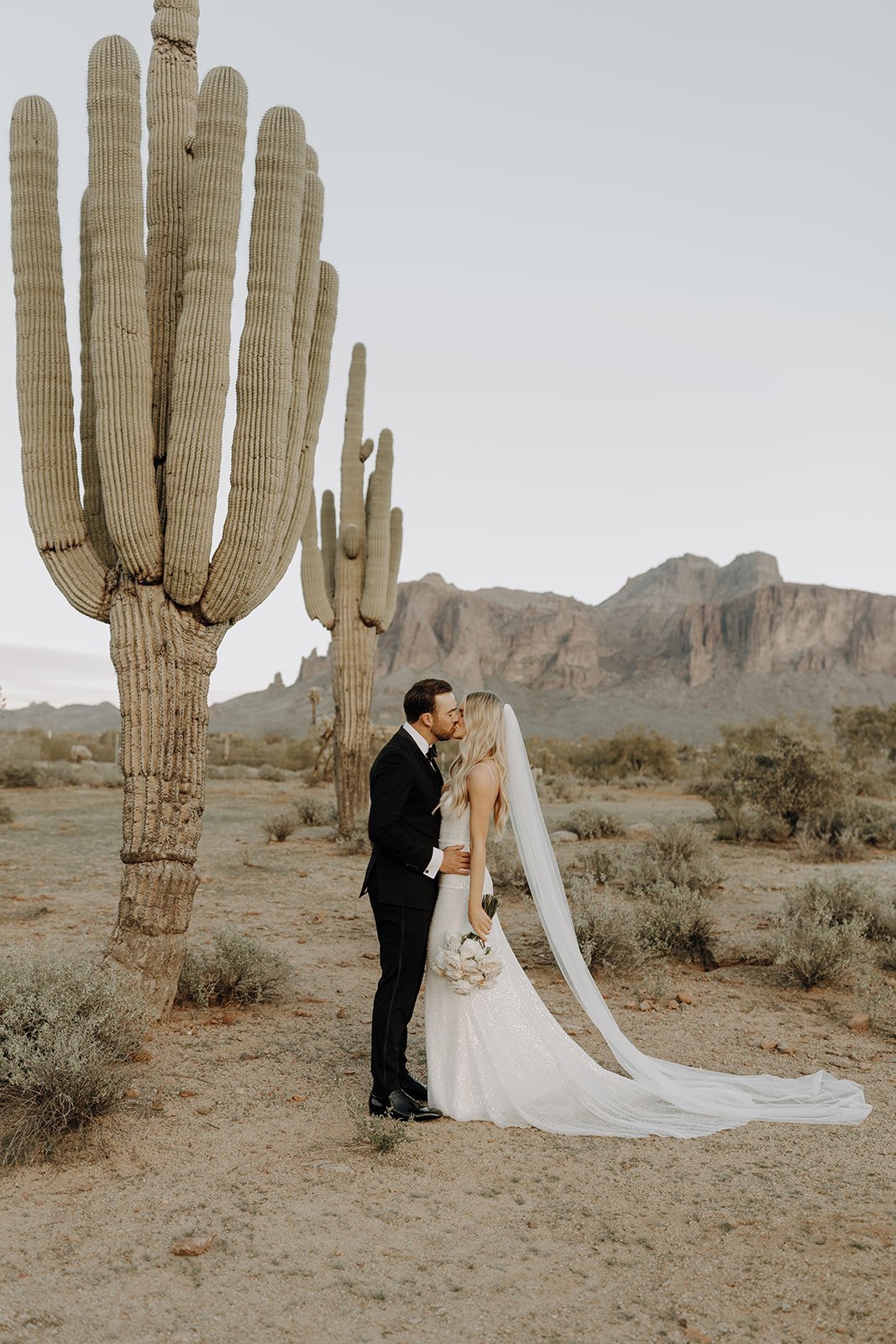 Bride and groom kiss in the Arizona desert for their desert wedding