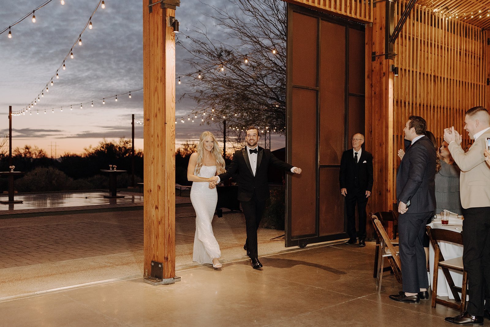 Bride and groom walk into the reception at The Paseo wedding venue