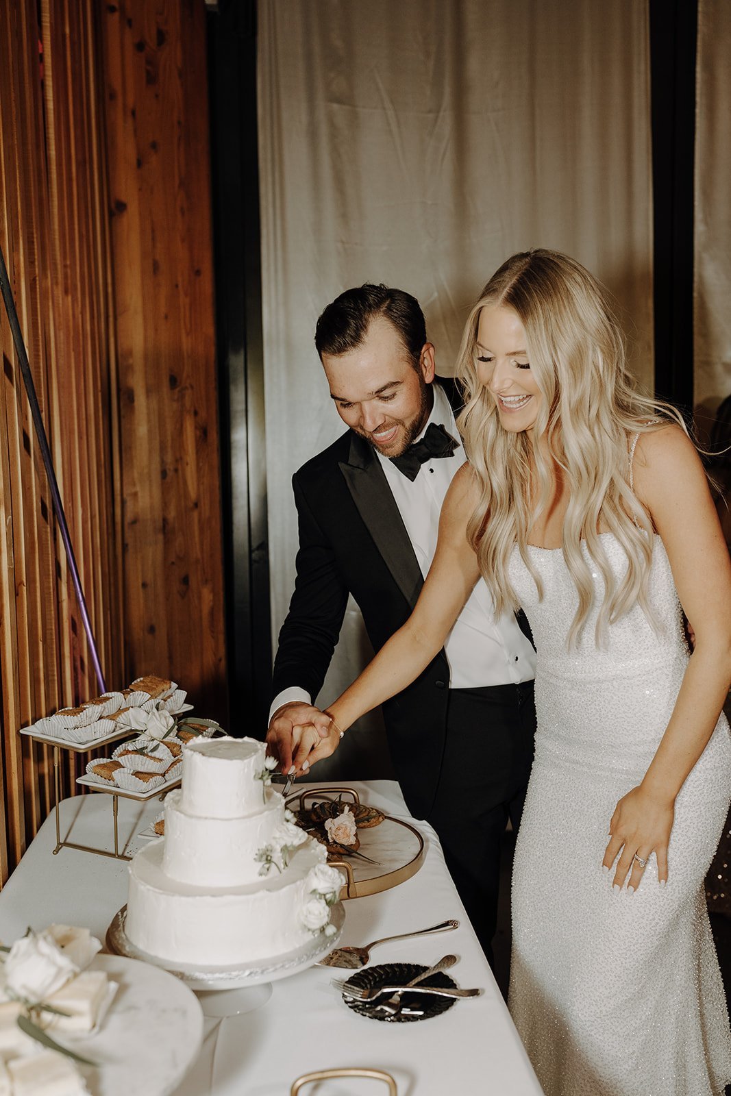 Bride and groom cut white wedding cake 