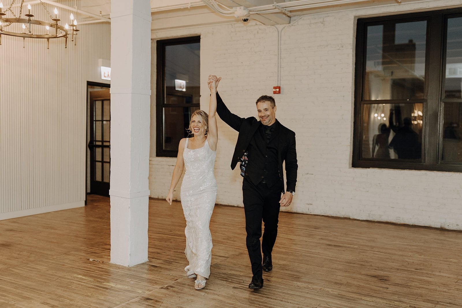 Bride and groom entering wedding reception at classic rock themed wedding