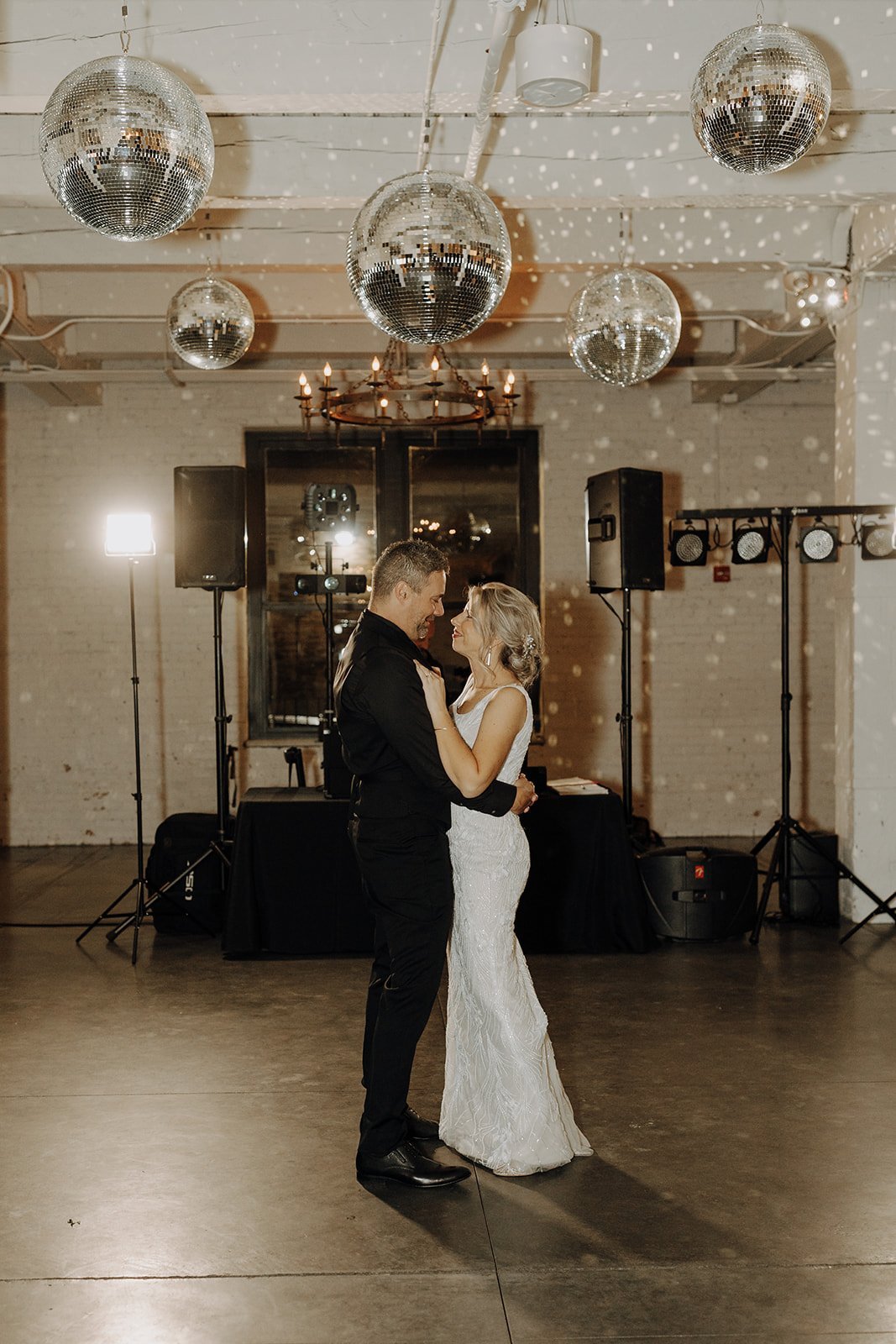 Bride and groom first dance under disco balls at non-traditional wedding in Illinois