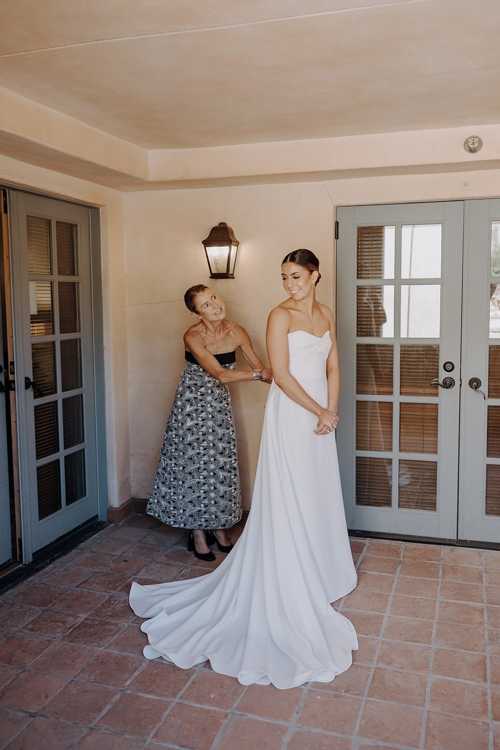 Bride gets helped into white wedding dress at Royal Palms Resort &amp; Spa