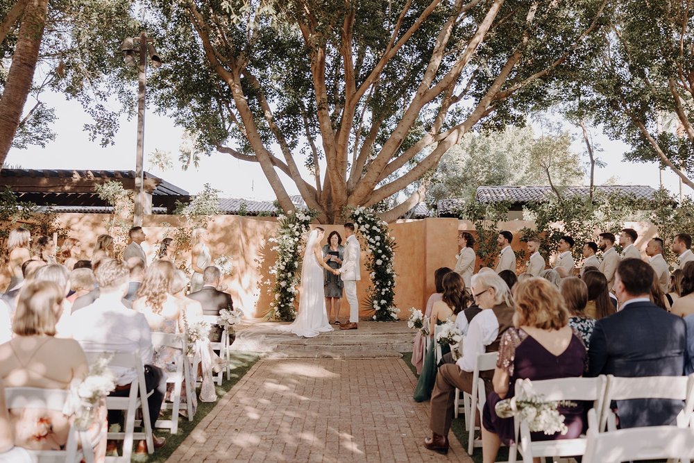 Bride and groom hold hands during the wedding ceremony at luxury resort wedding in Arizona