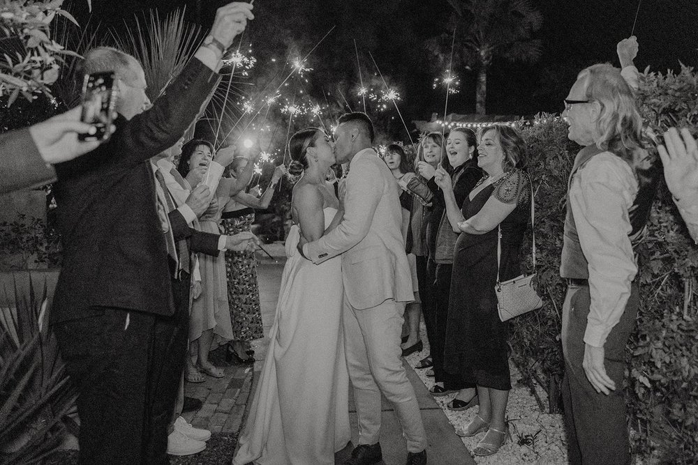 Bride and groom kiss during sparkler exit at luxury resort wedding in Arizona