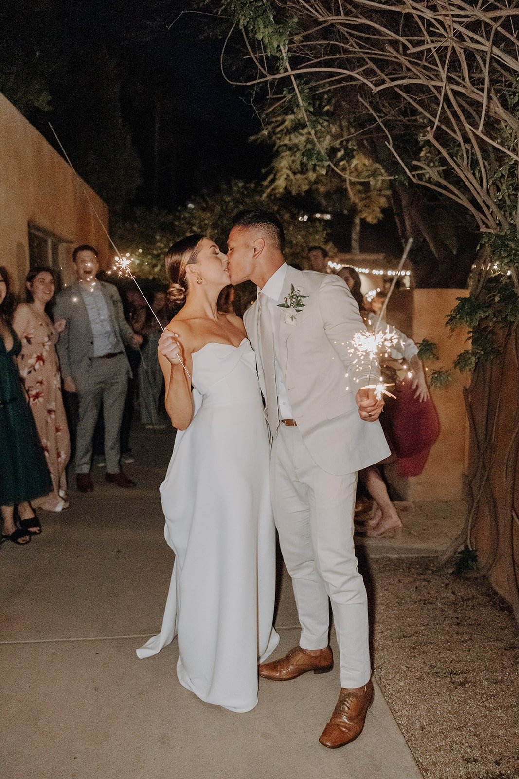 Bride and groom kiss during sparkler exit at luxury resort wedding in Arizona