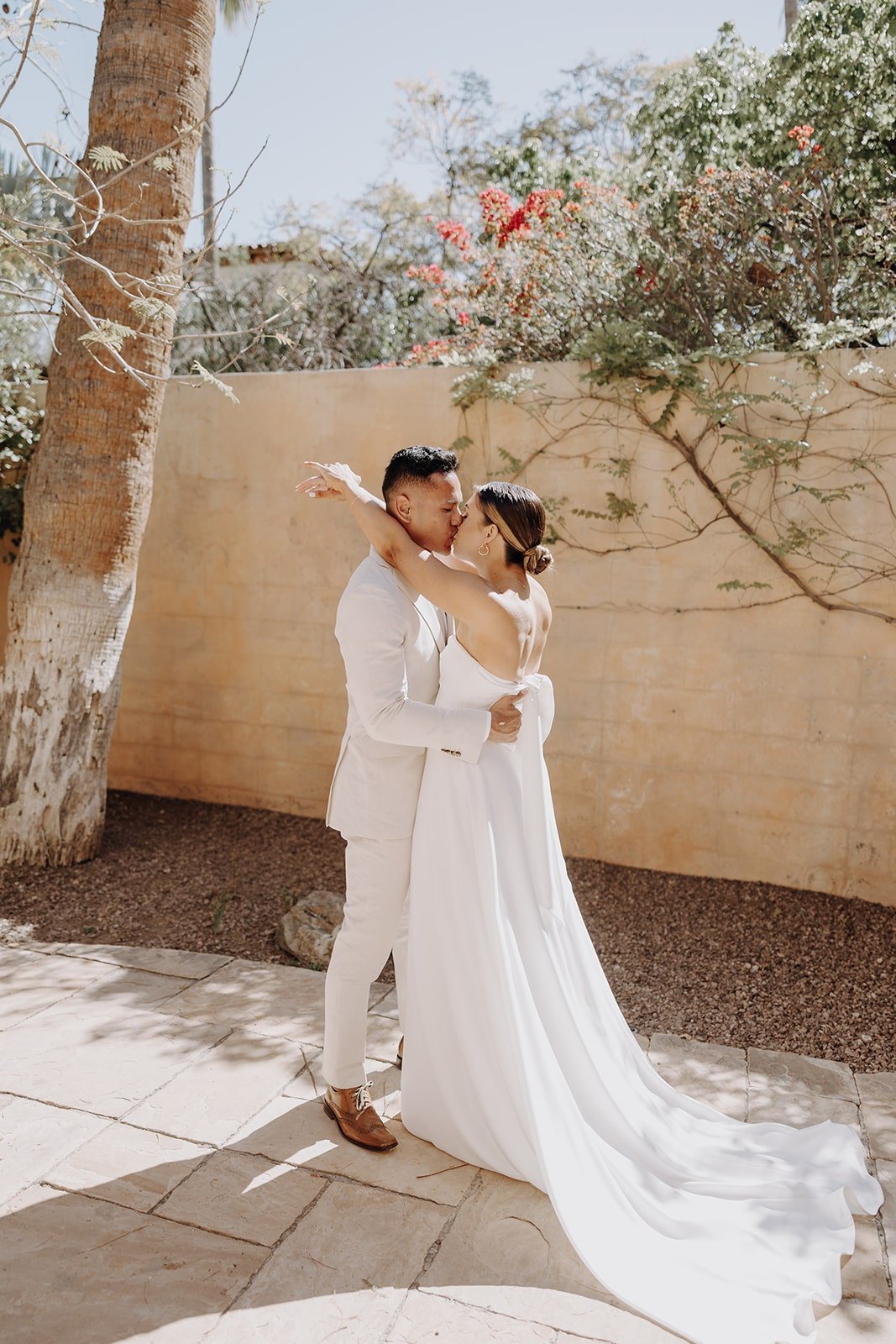 Bride and groom kiss after first look at Royal Palms Resort &amp; Spa