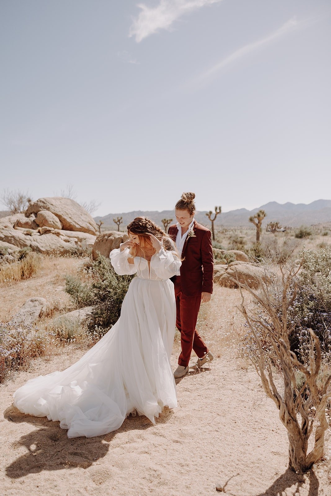 Bride spins to show groom her wedding dress during wedding first look in Joshua Tree