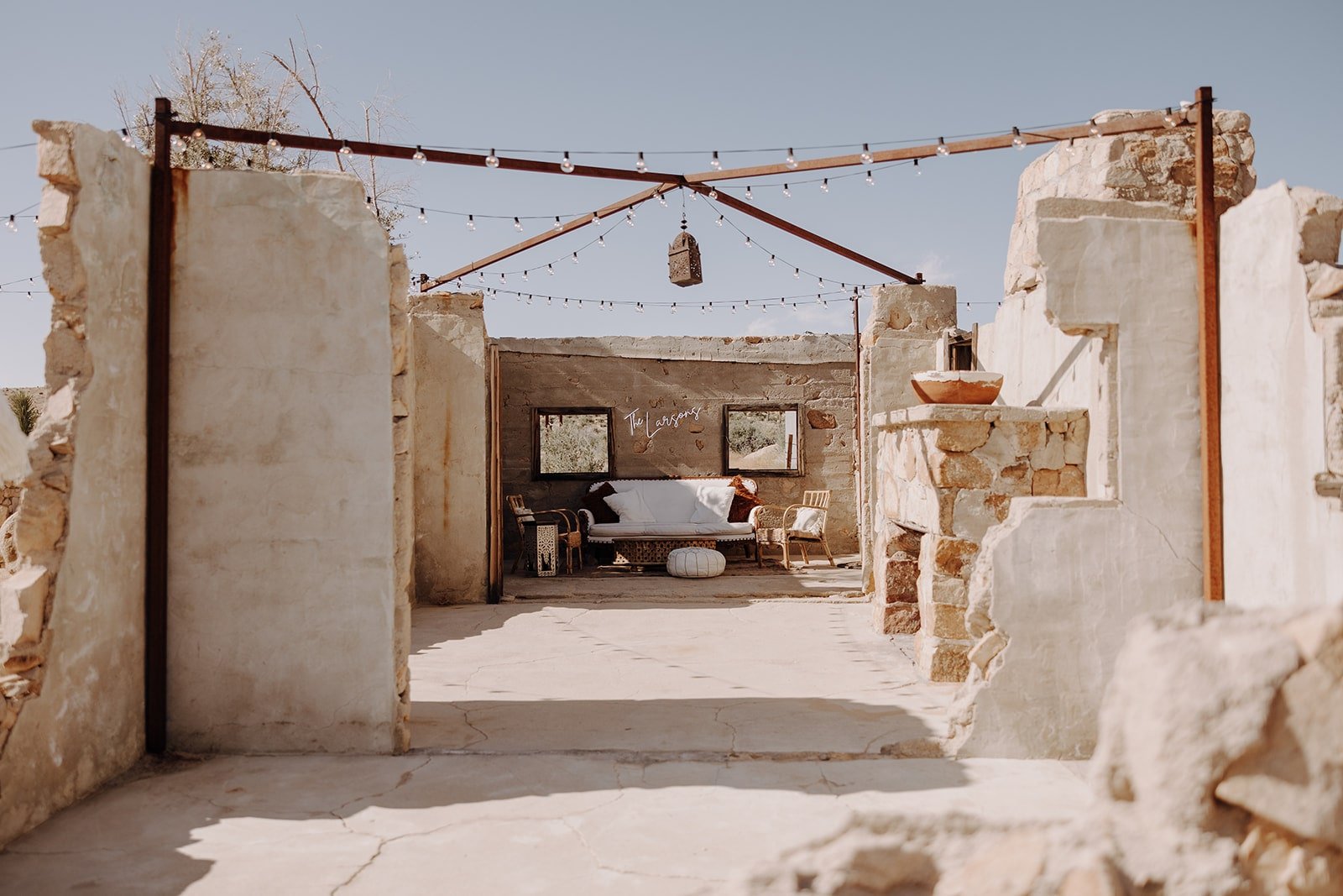 The Ruin Venue outdoor seating at Joshua Tree with neon sign that reads "The Larsons"