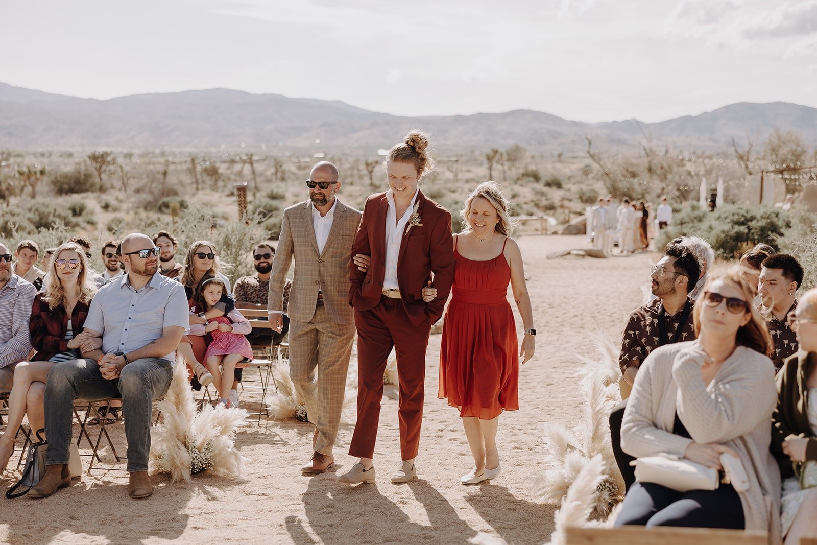 Groom enters outdoor wedding ceremony at Joshua Tree with parents