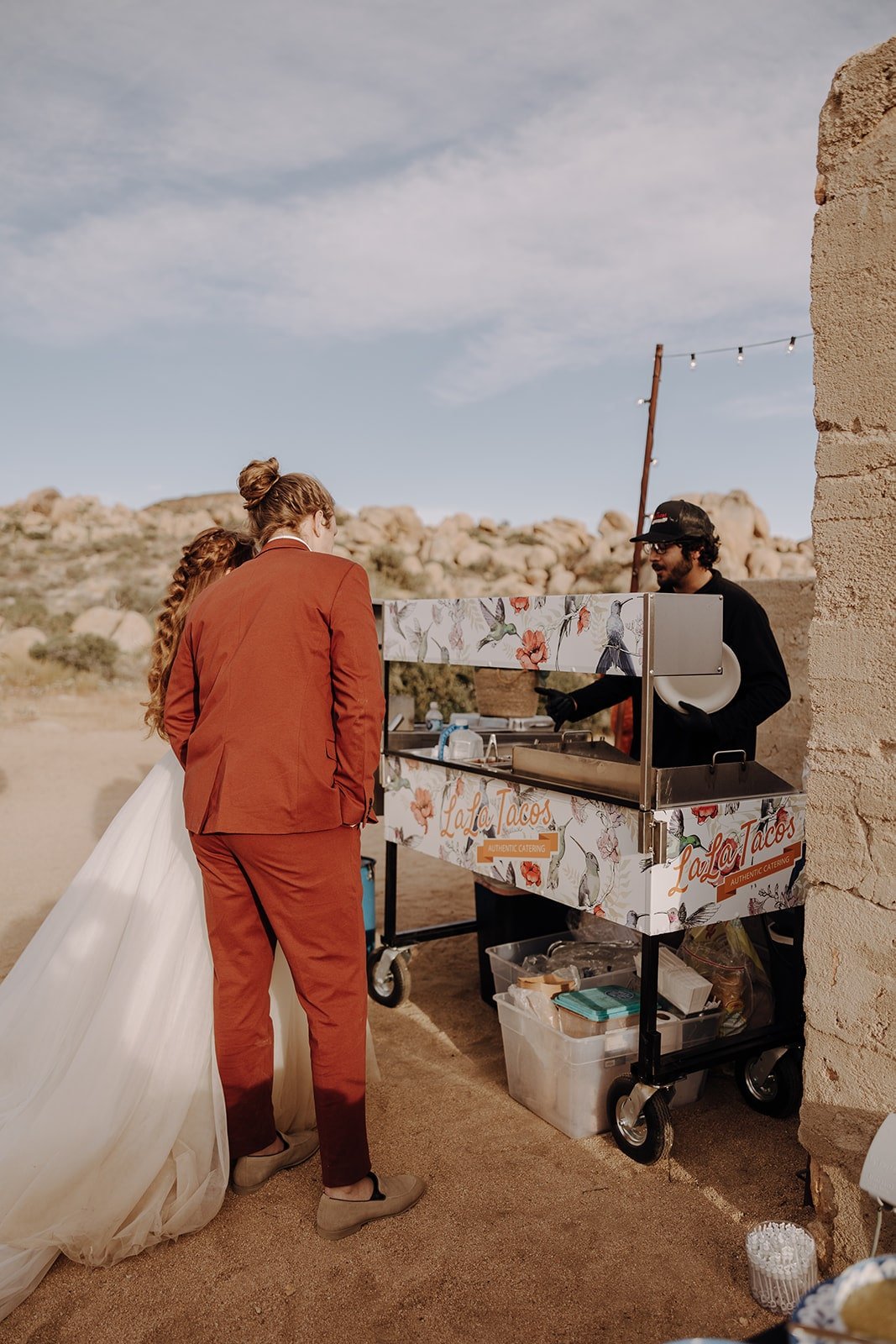 Bride and groom get food from taco cart at Joshua Tree wedding in California