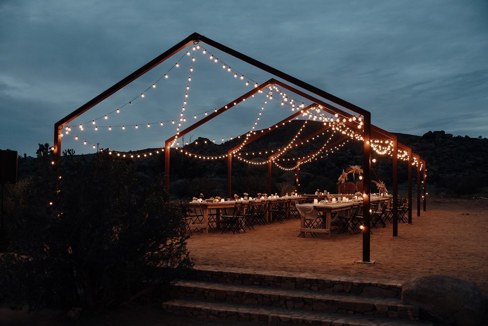 The Ruin Venue outdoor wedding reception area with string lights on wood arches