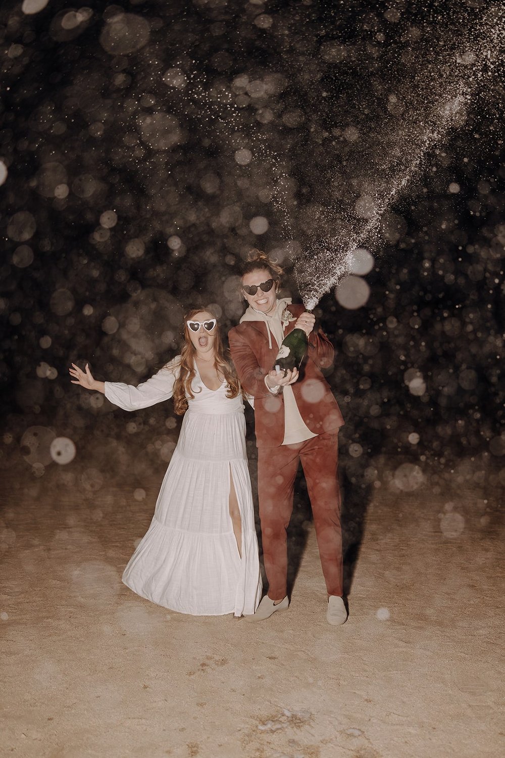 Bride and groom pop champagne to celebrate their wedding in Joshua Tree