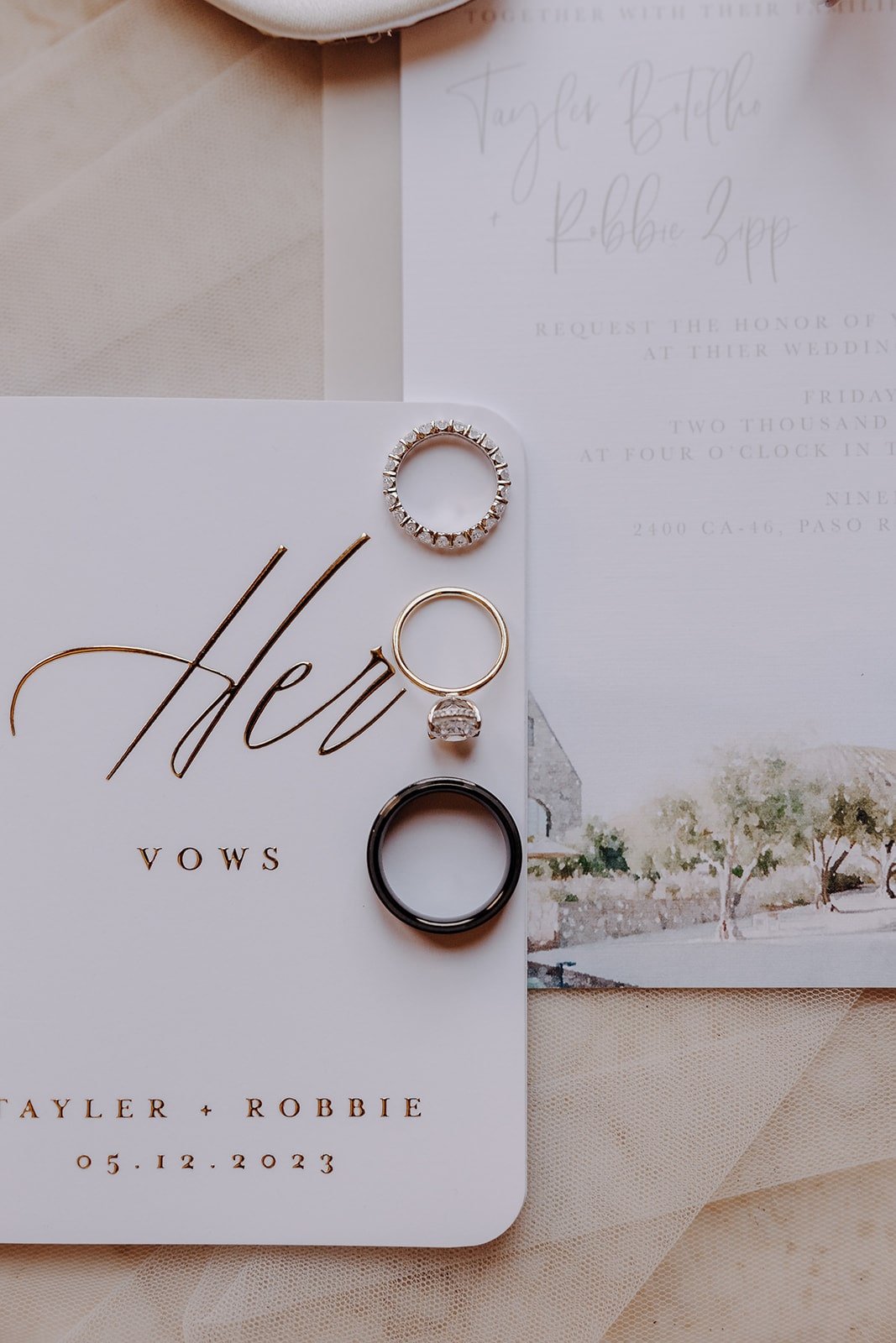Three wedding bands sitting on top of a white vow book 