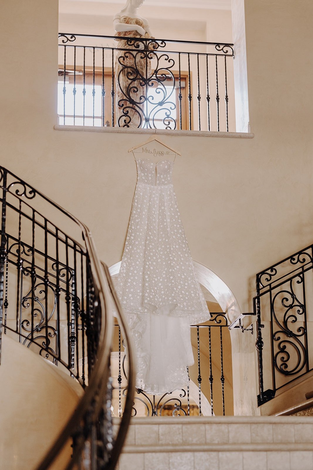 White wedding dress hanging from the balcony at luxury wedding venue in California