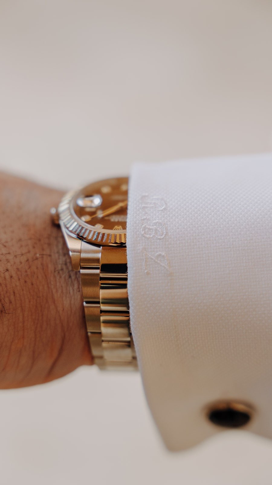 Luxury groom wedding details with customized dress shirt with black cuff links and rolex watch