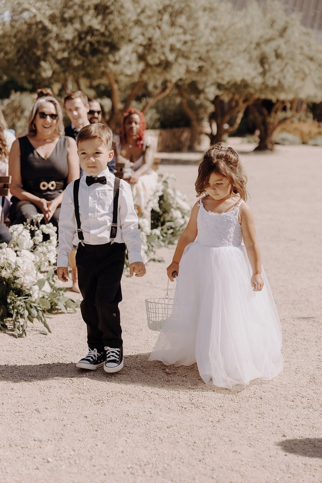 Flower girl and boy walk down the wedding aisle at Tuscan-style wedding in California