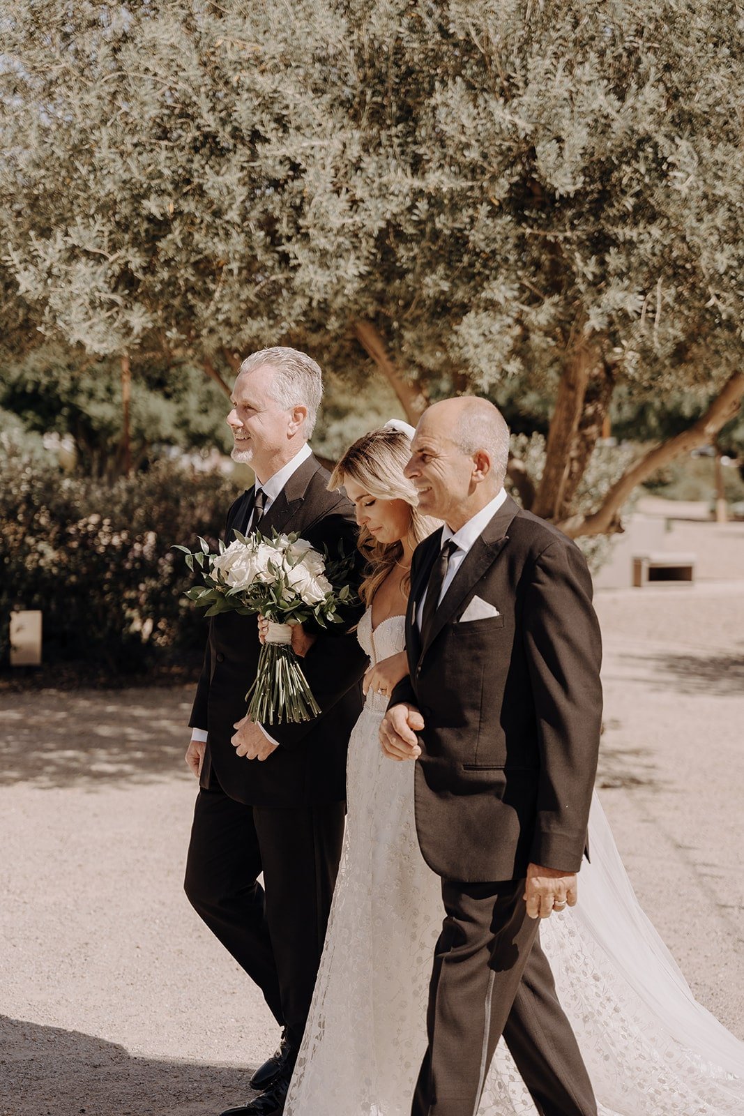 Bride enters the wedding ceremony with her two fathers