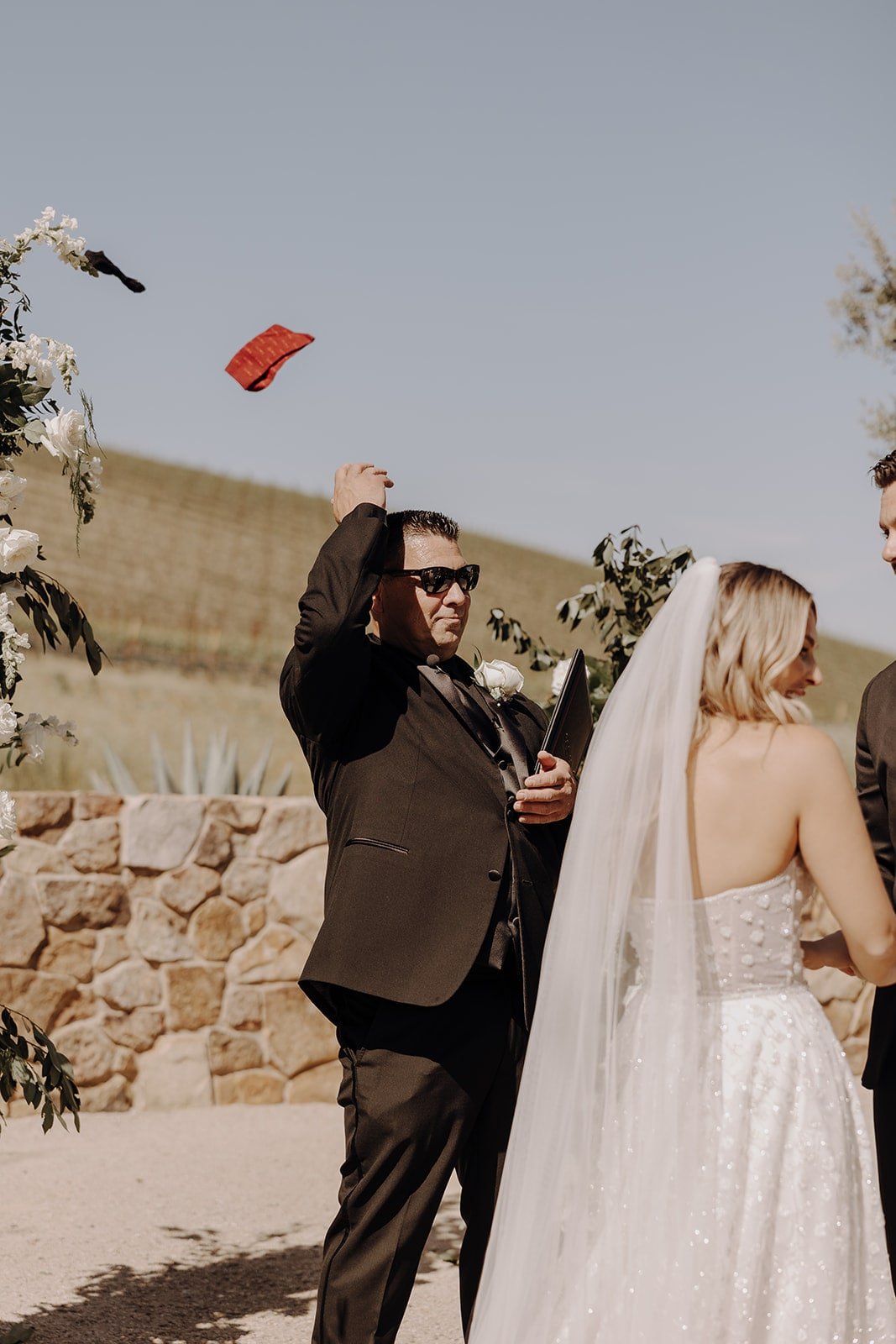 Officiant throws the wedding script at outdoor wedding ceremony in California
