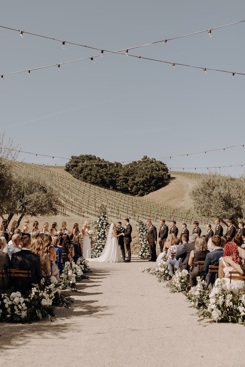 Bride and groom hold hands at their Tuscan-style wedding ceremony