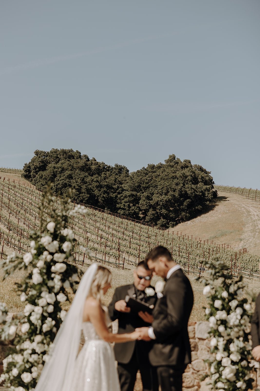 Bride and groom hold hands during their Tuscan-style wedding ceremony