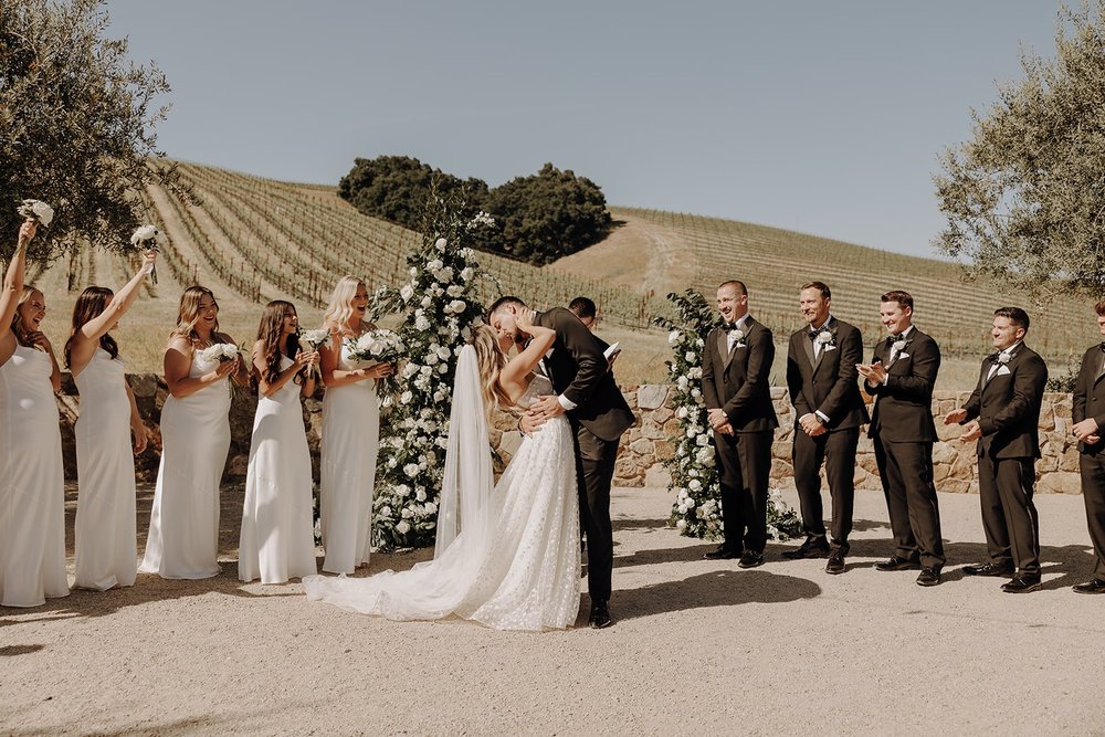 Bride and groom kiss during their luxury wedding ceremony in California