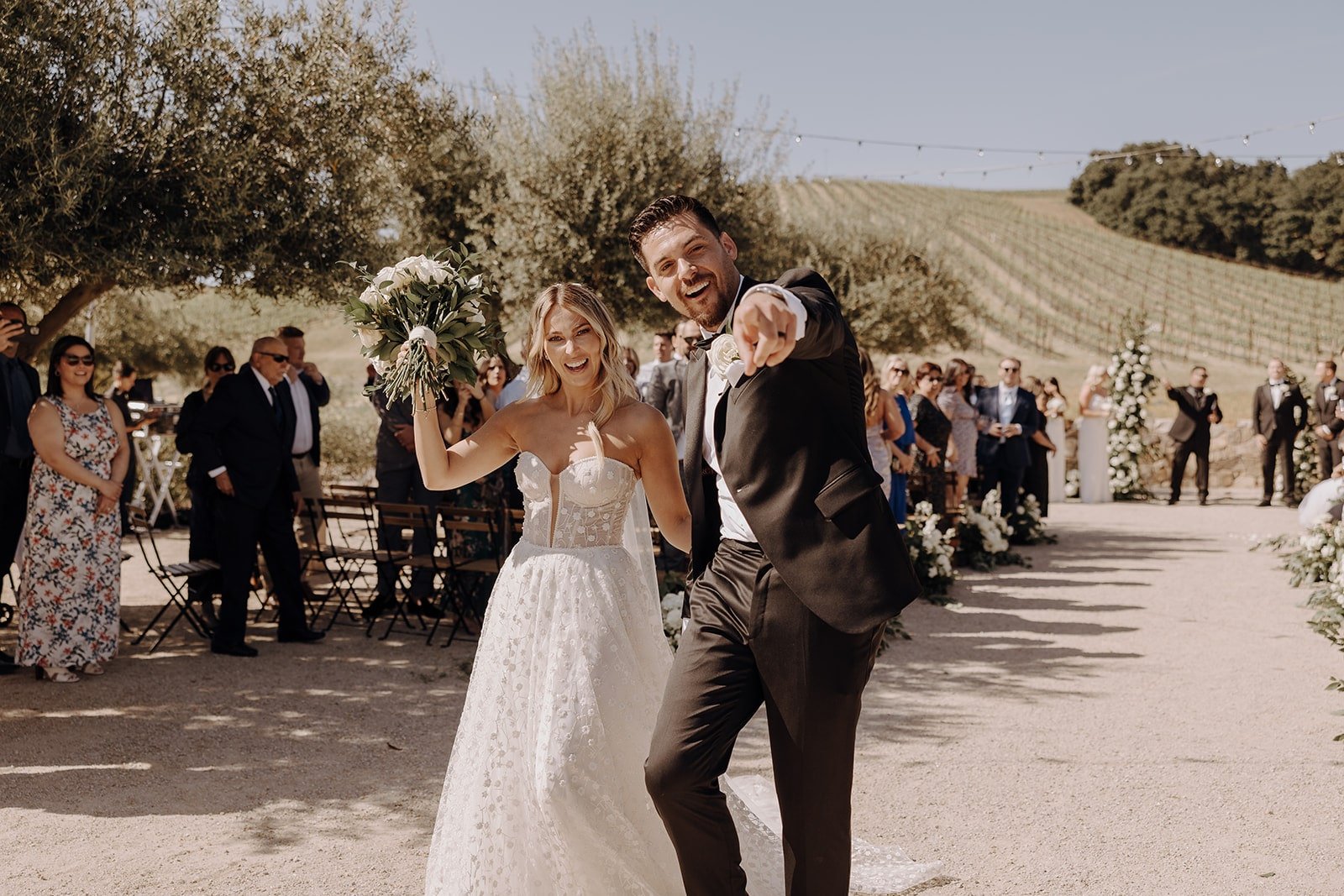 Bride and groom cheer as they exit their wedding ceremony in California