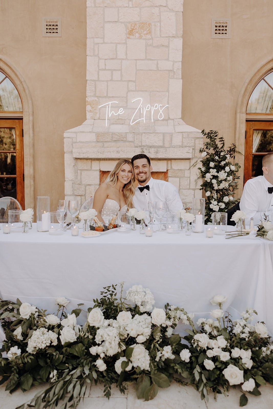 Bride and groom sit at the head table during luxury wedding reception at Allegretto Vineyard Resort